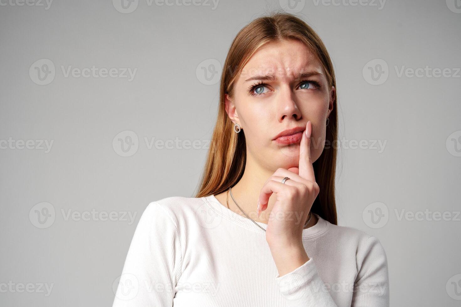Young Woman Holding Hand to Face on gray background photo