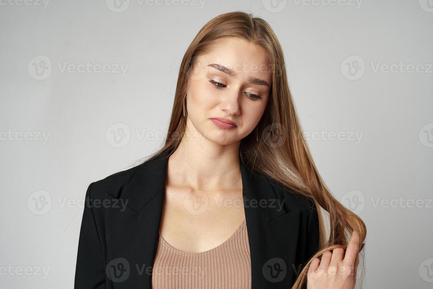 Young Woman in Black Jacket Posing to Camera against gray background photo