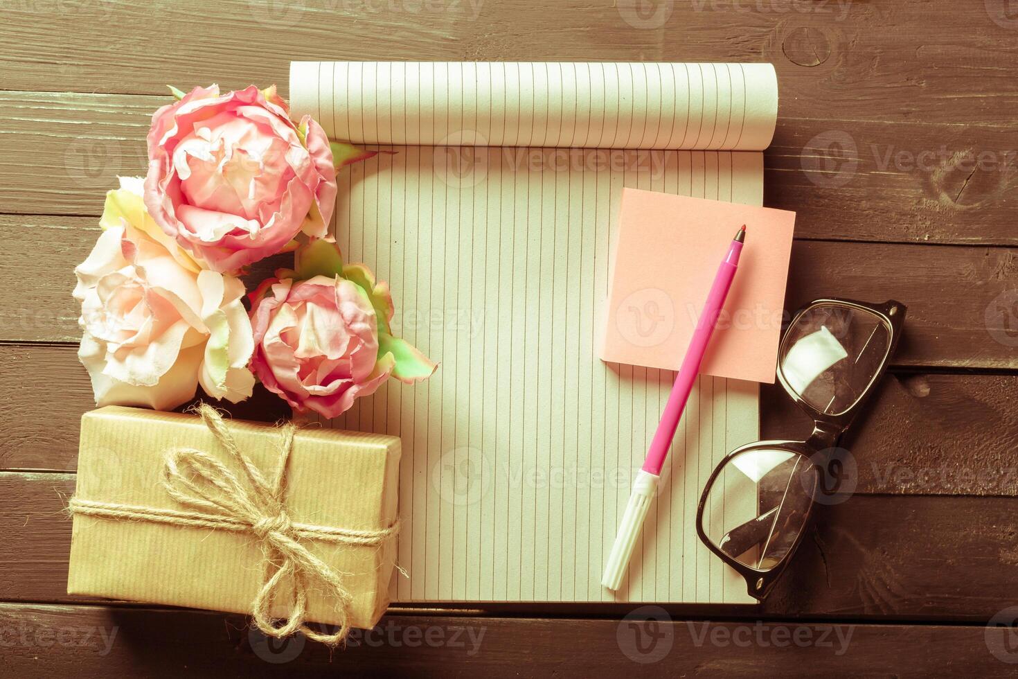 flowers and a notebook on wooden background photo