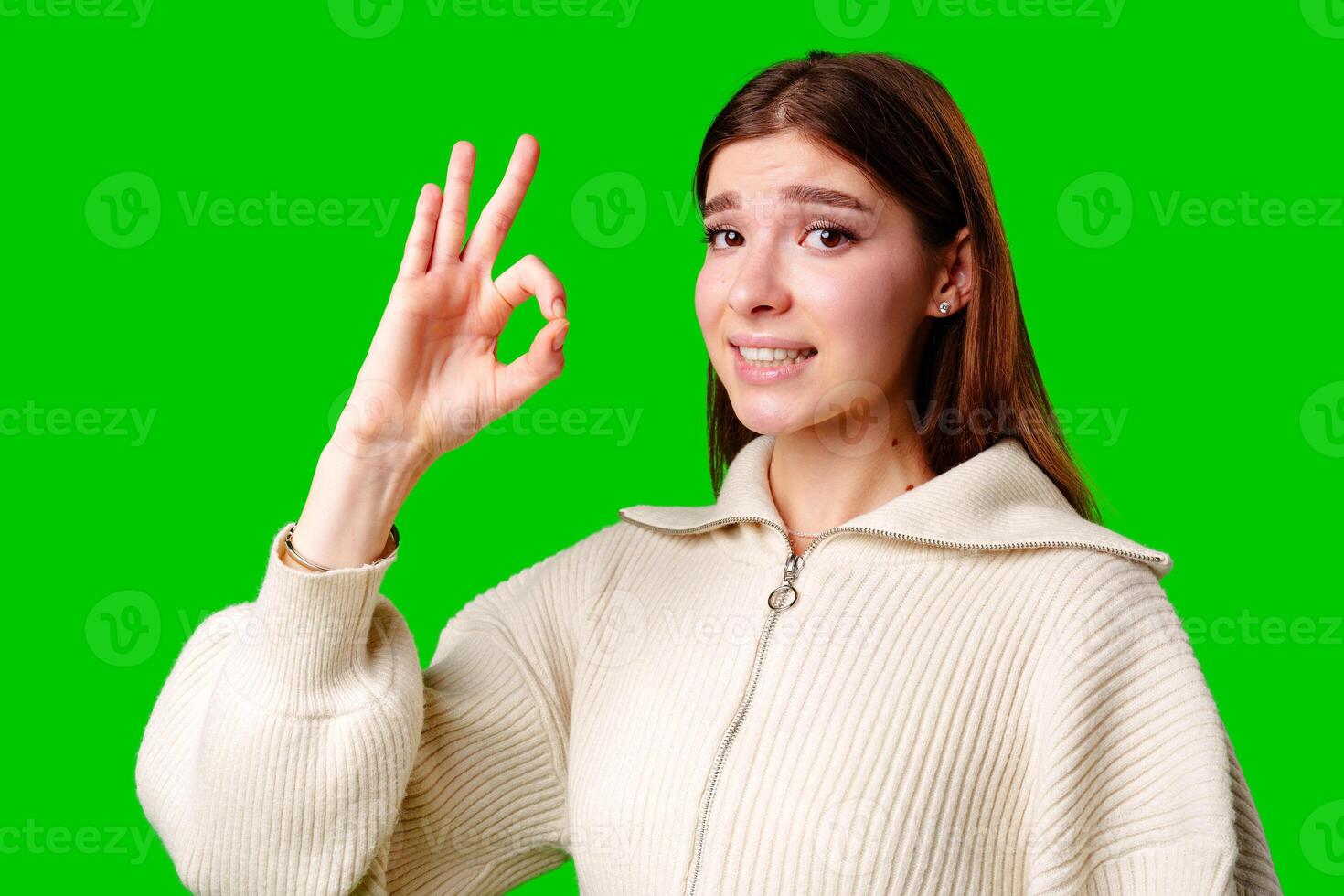 A woman dressed in a skirt and sweater is standing and waving her hand in the air, possibly in a greeting or to get someones attention. photo