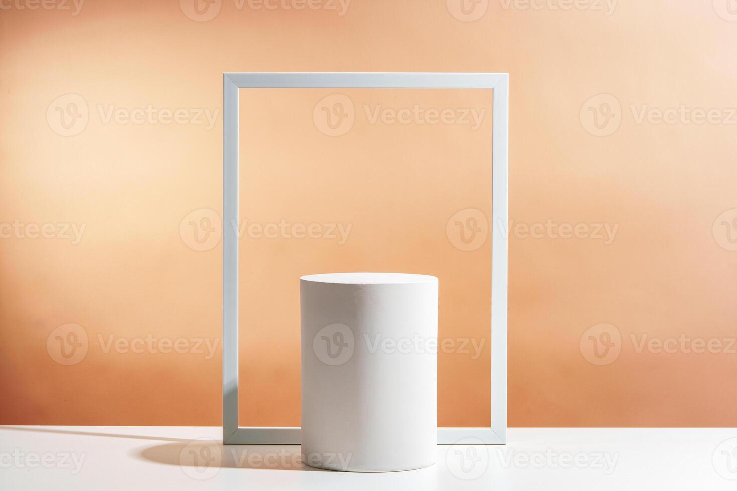 Minimalistic display of a white cylindrical object framed by a white rectangular border against a soft orange background photo