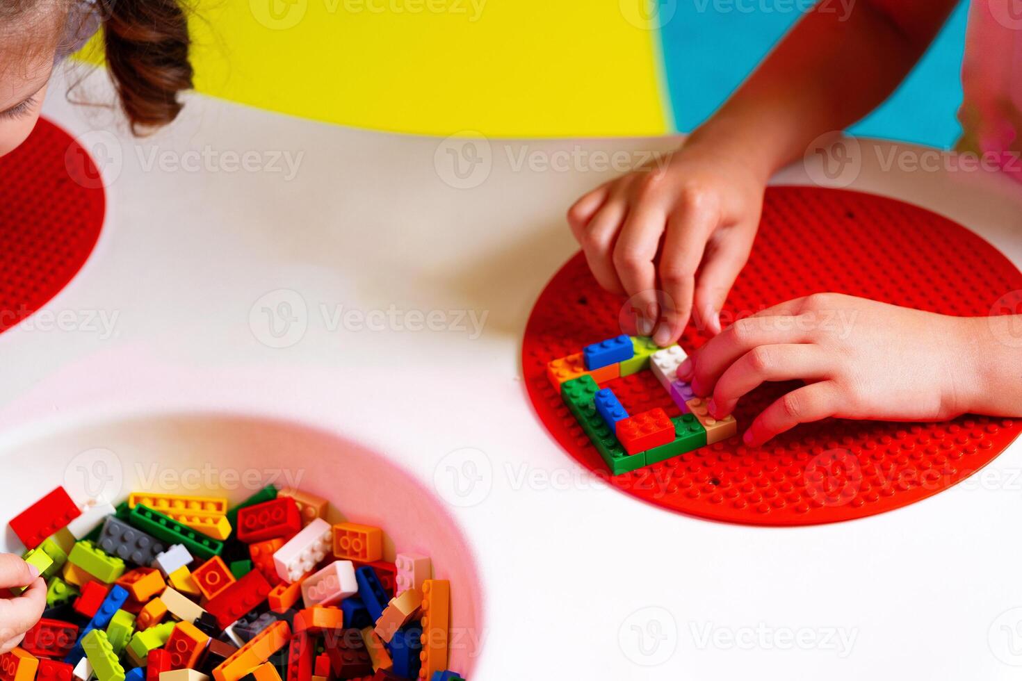Child Engaged in Creative Play With Colorful Building Blocks on a Round Base photo