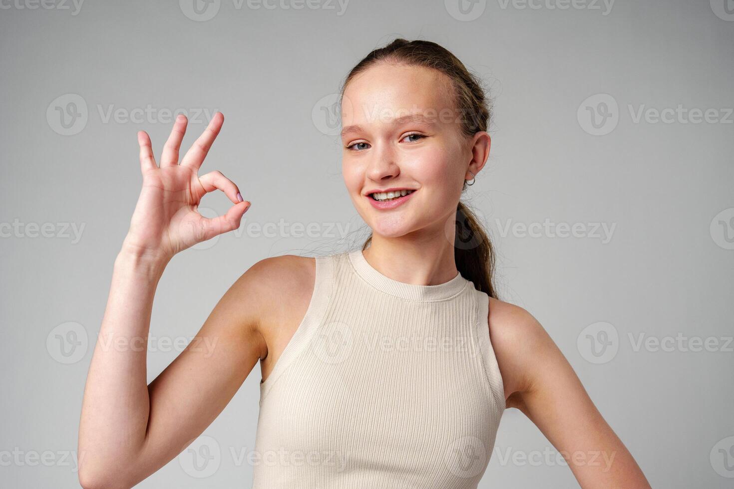 Young Girl Giving Thumbs Up Sign in studio photo