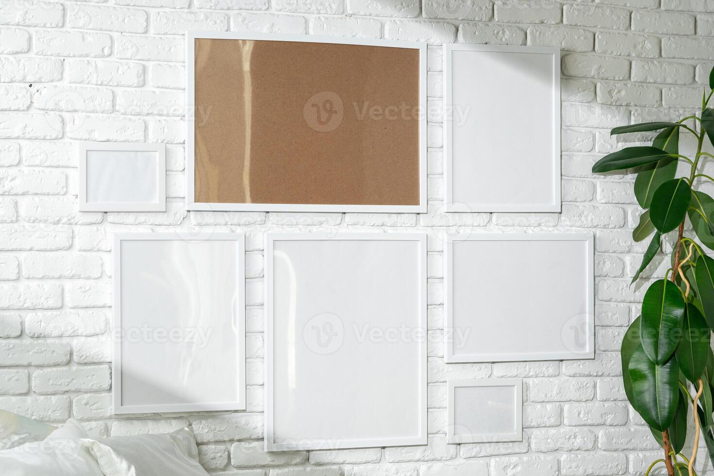 Varied Sized Photo Frames Displayed on a White Brick Wall