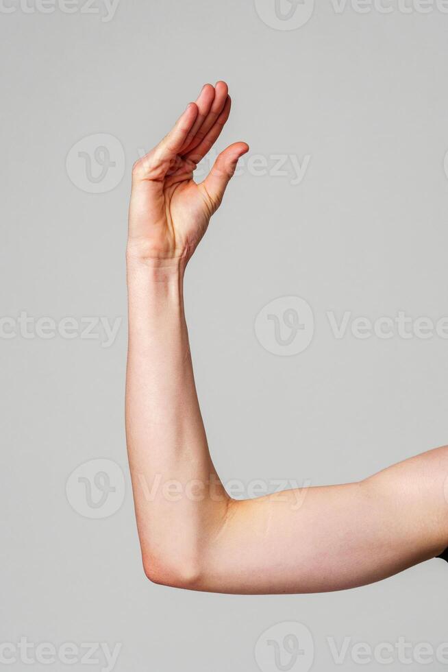 Close-Up of a Human Arm Extended Against a Plain Background photo