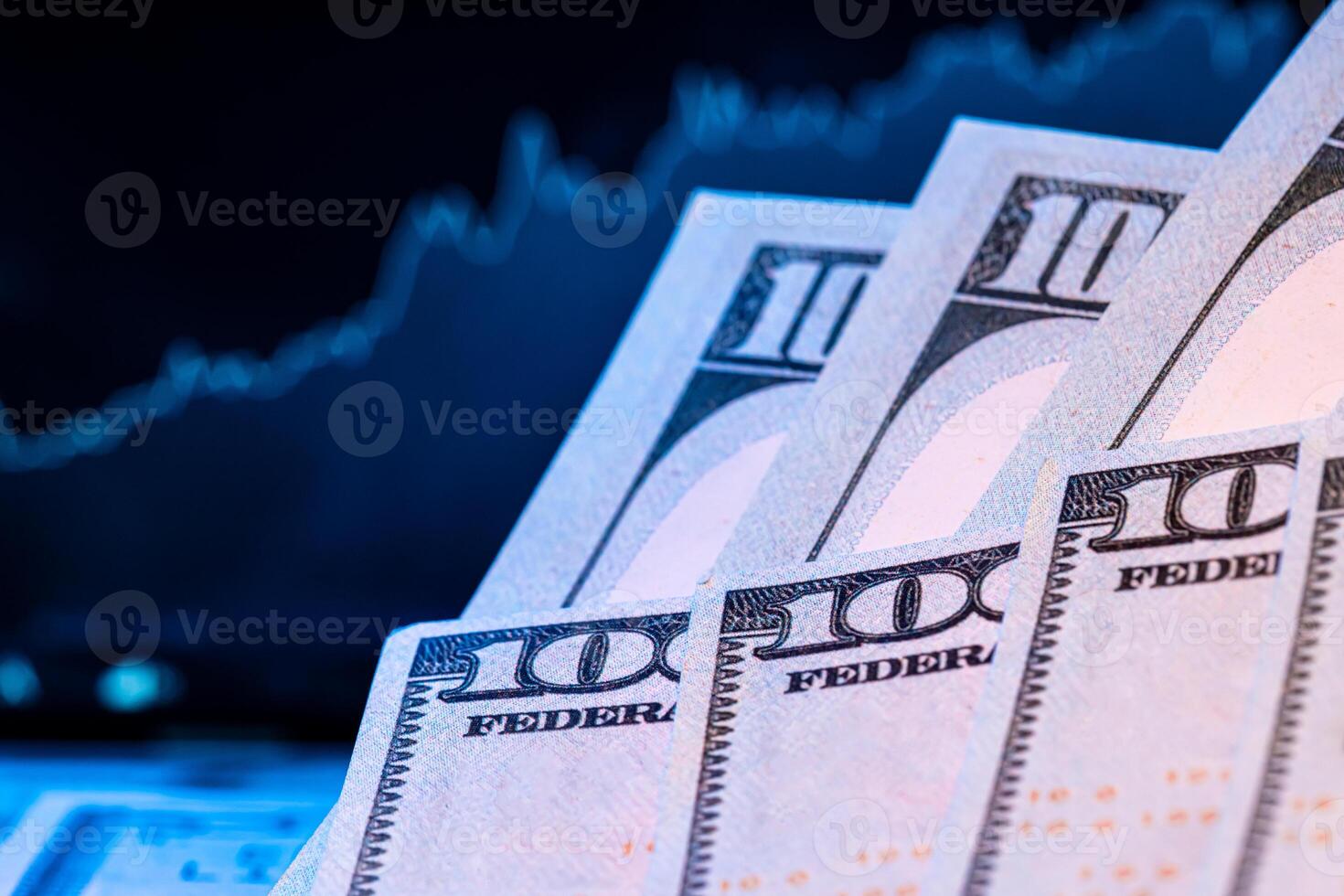 Dollars in front of a monitor with a price chart. Forex and trading. photo