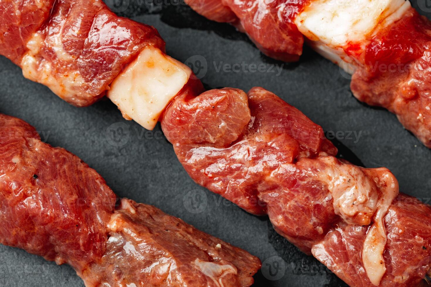 Raw beef kebab with herbs on a dark board photo