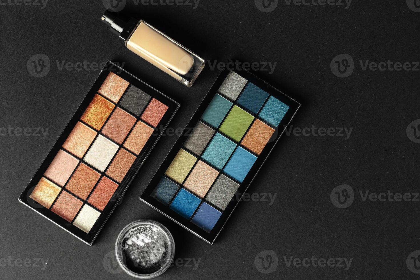 Professional makeup brushes and tools, make-up products set on dark table photo