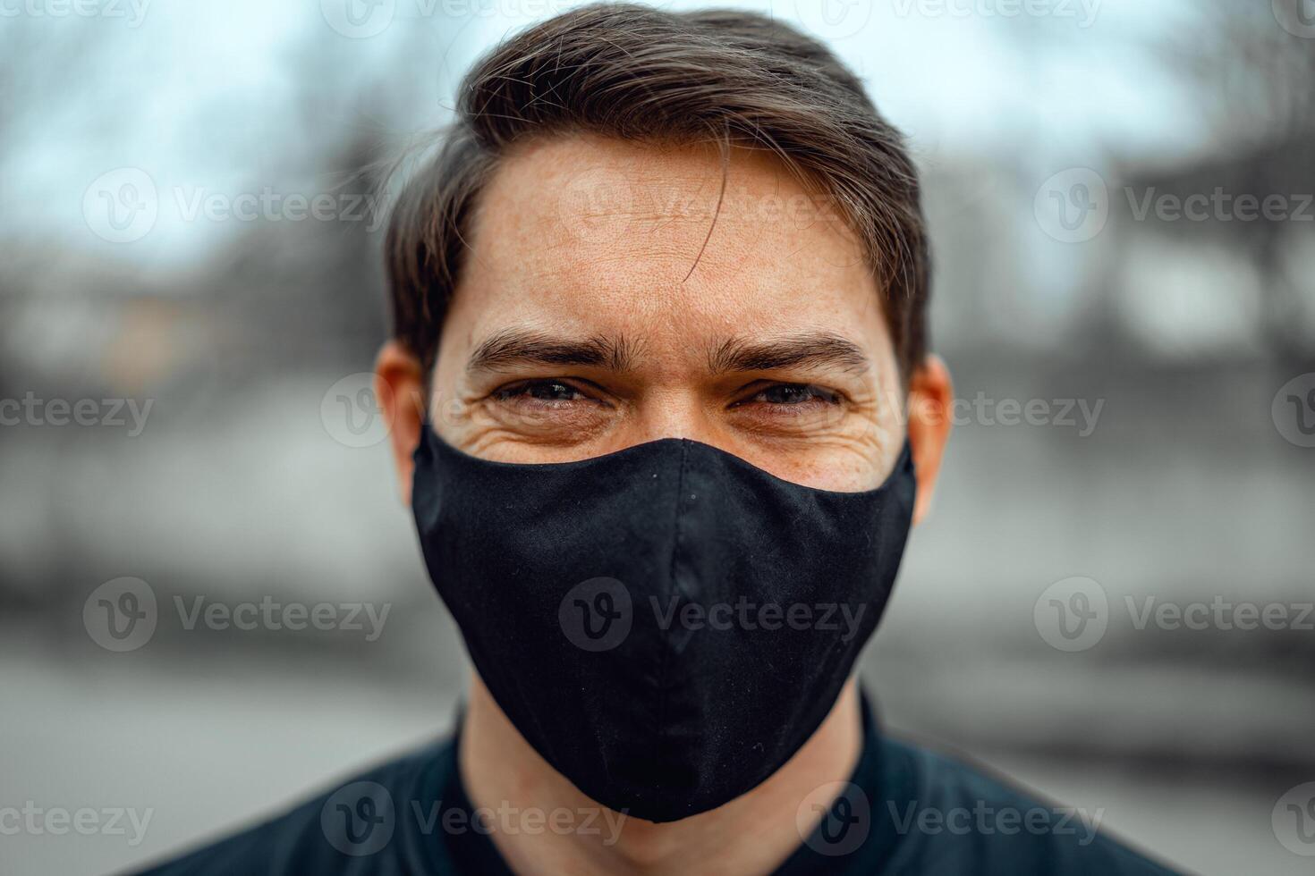 Portrait man in medical mask. Young man stands on light background and looking at camera. COVID-19 Pandemic Coronavirus. photo