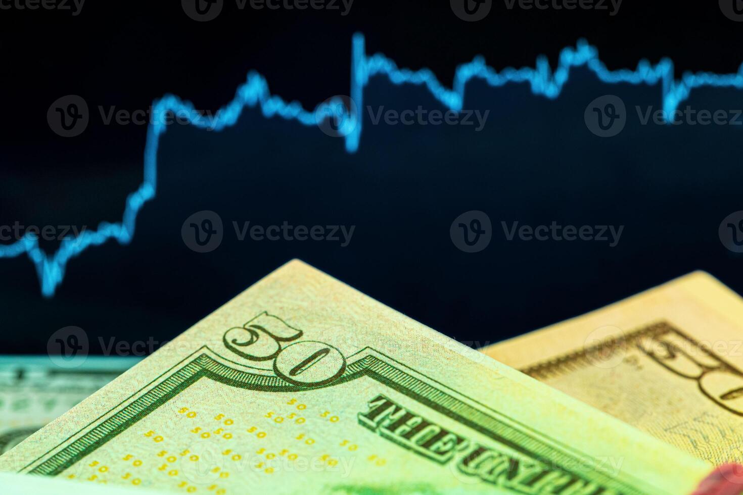 Dollars in front of a monitor with a price chart. Forex and trading. photo
