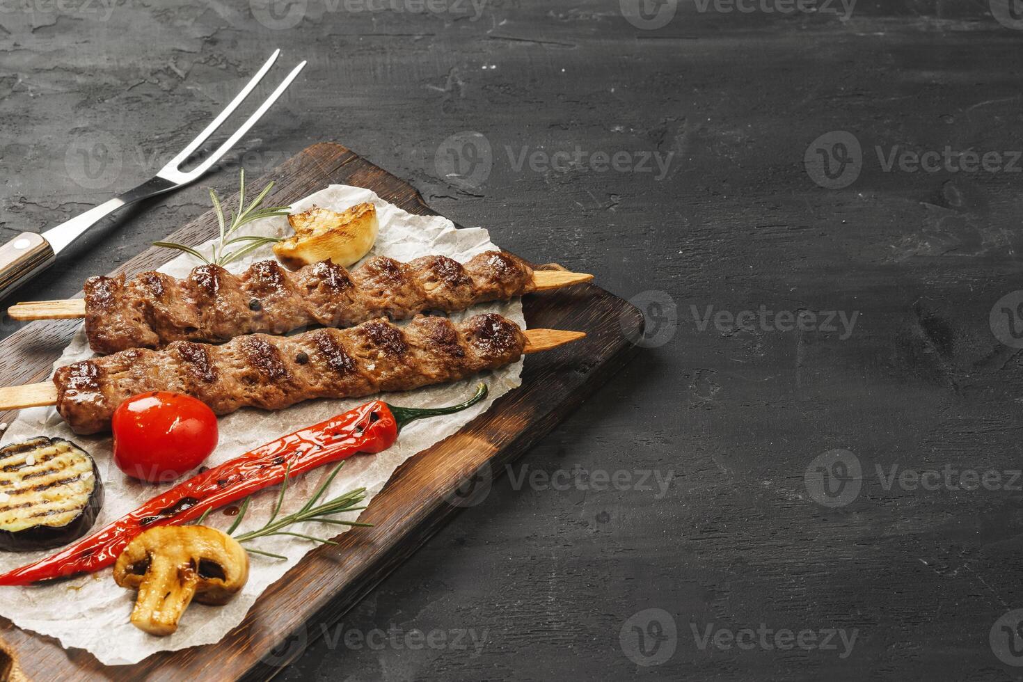 Grilled Lula kebab on skewers served on wooden board photo