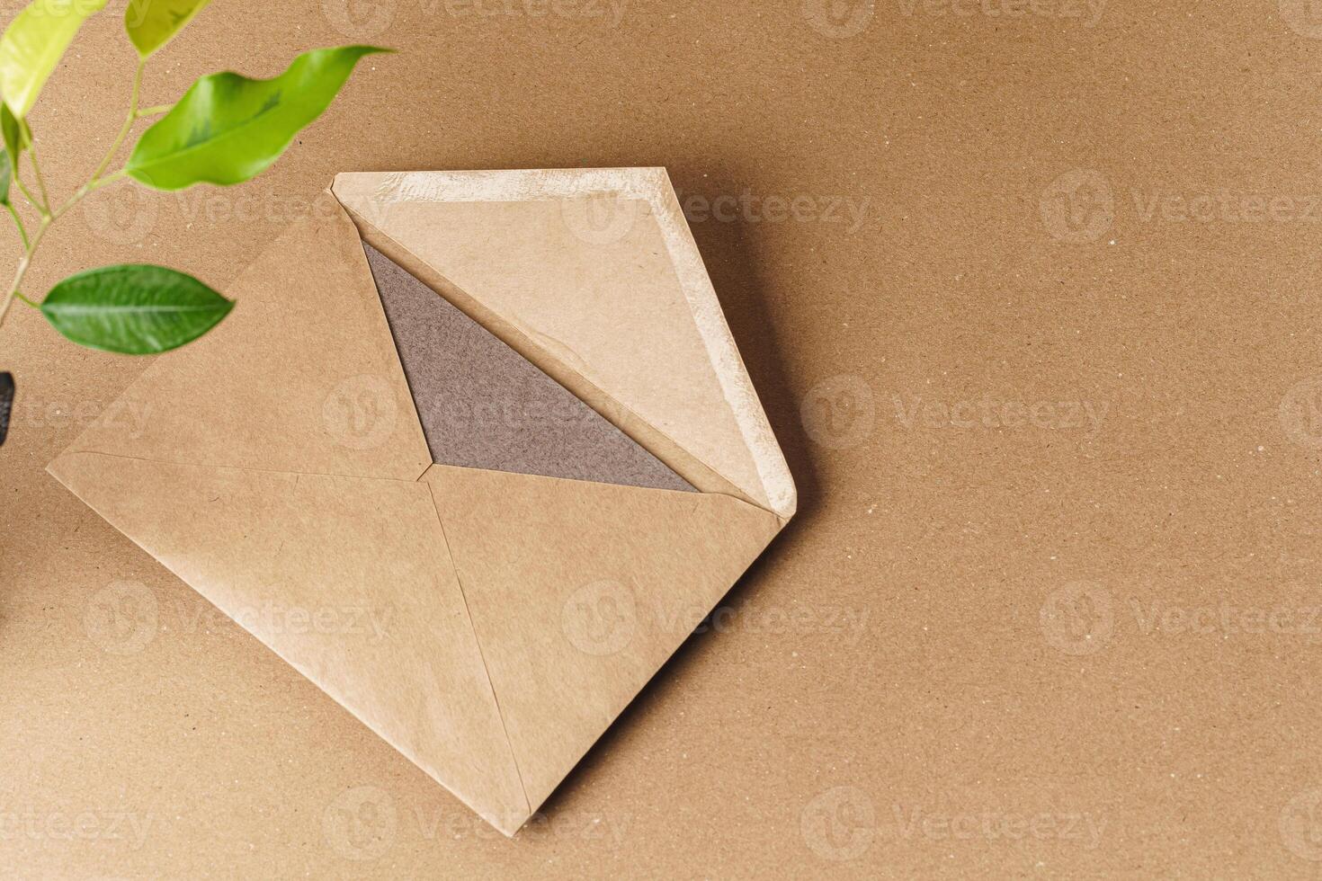 Flat lay craft paper card mockup with leaves photo