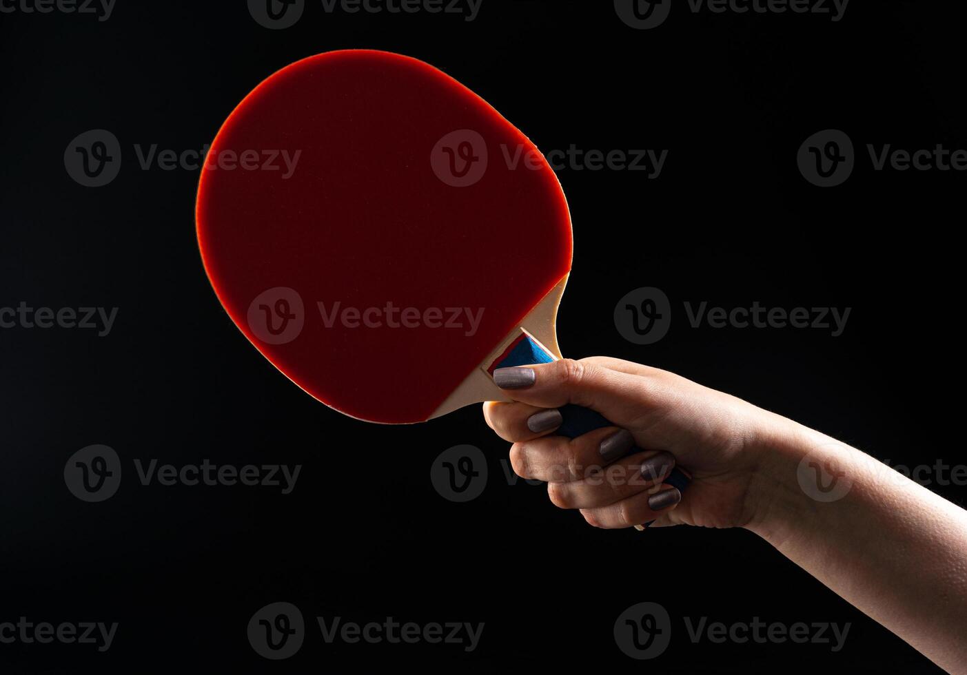 Red ping pong racket on dark background photo