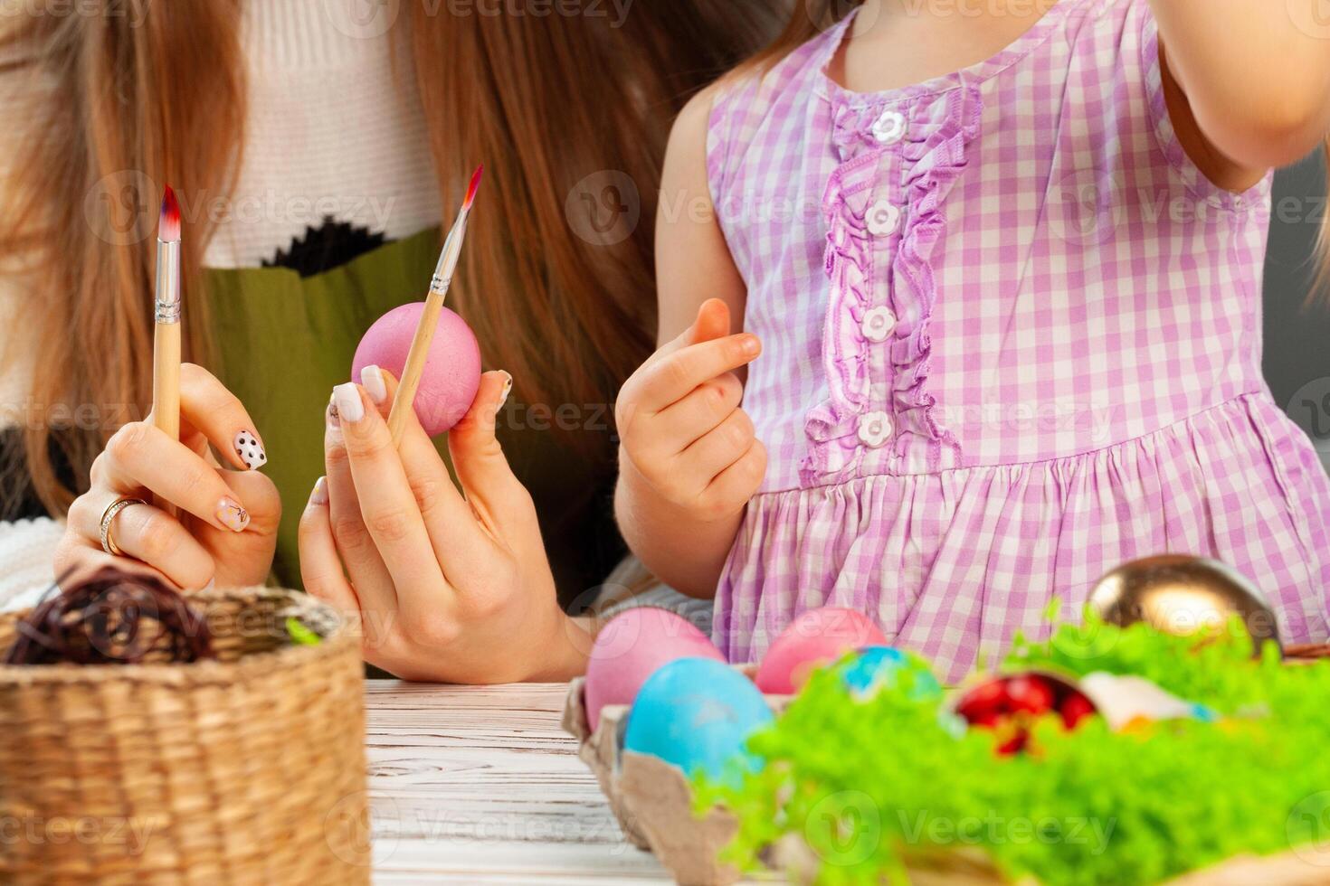 Mother and daughter coloring eggs for Easter photo