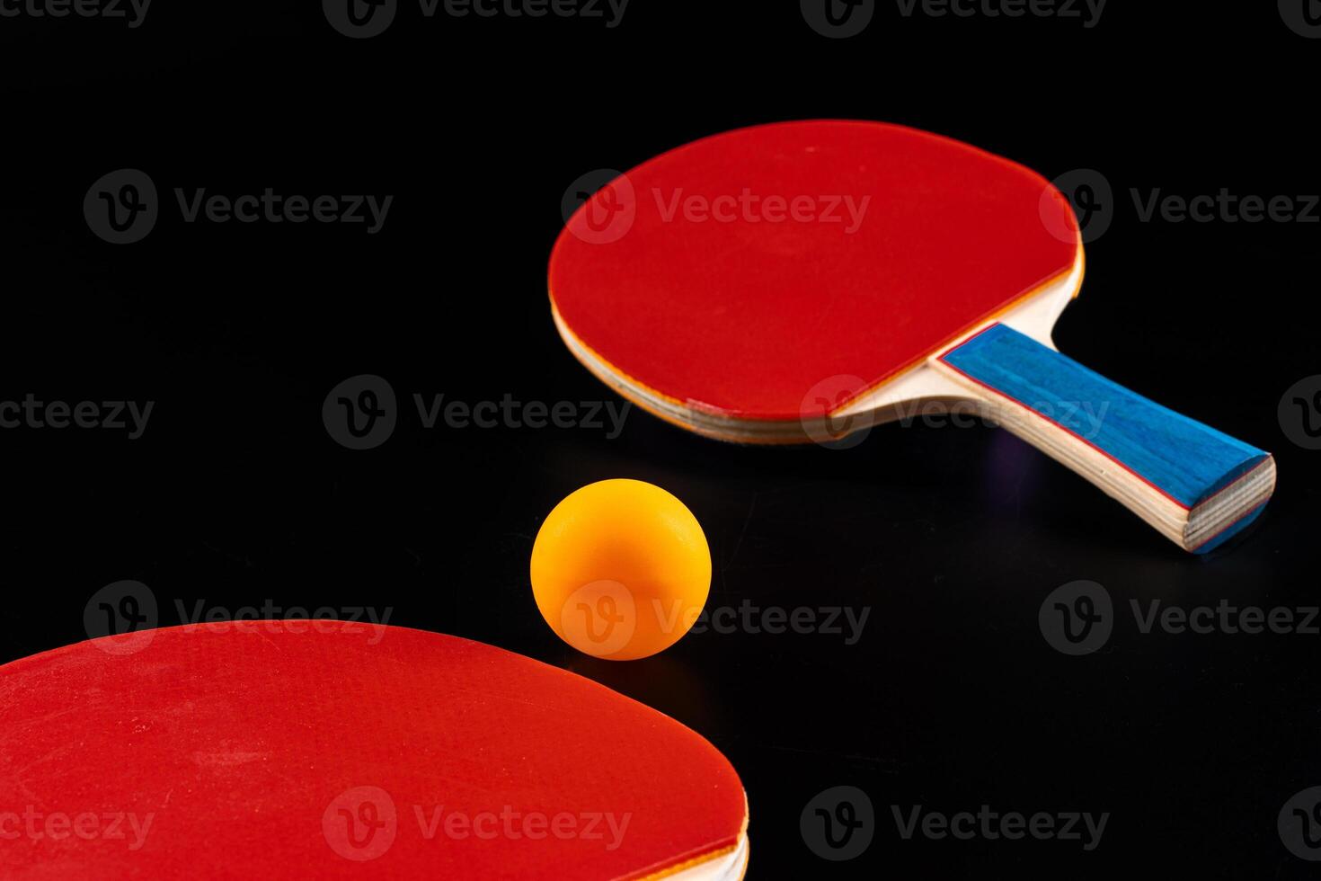 Red ping pong racket on dark background photo