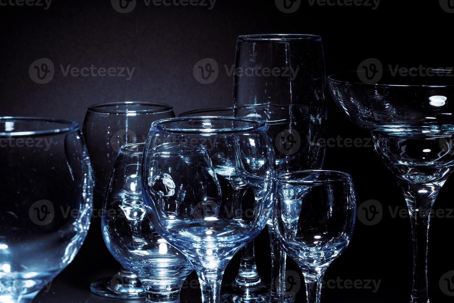 Empty glasses for drinks on dark background photo