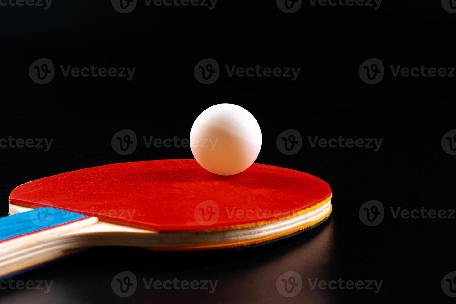 Red ping pong racket on dark background photo