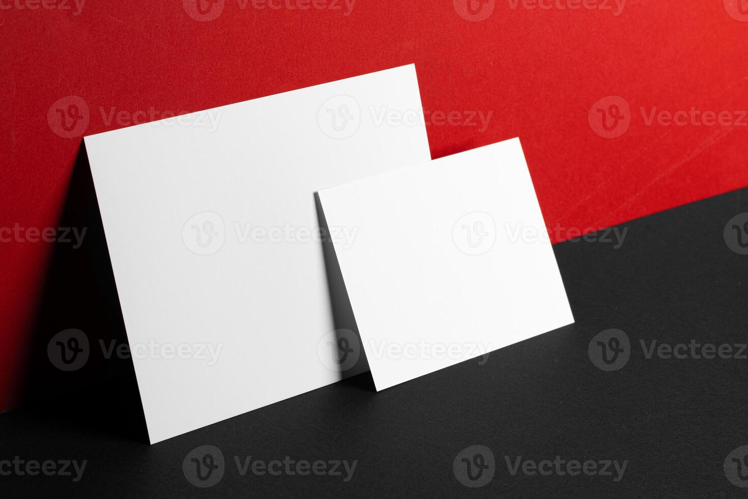 Blank white business cards on red and black paper background photo
