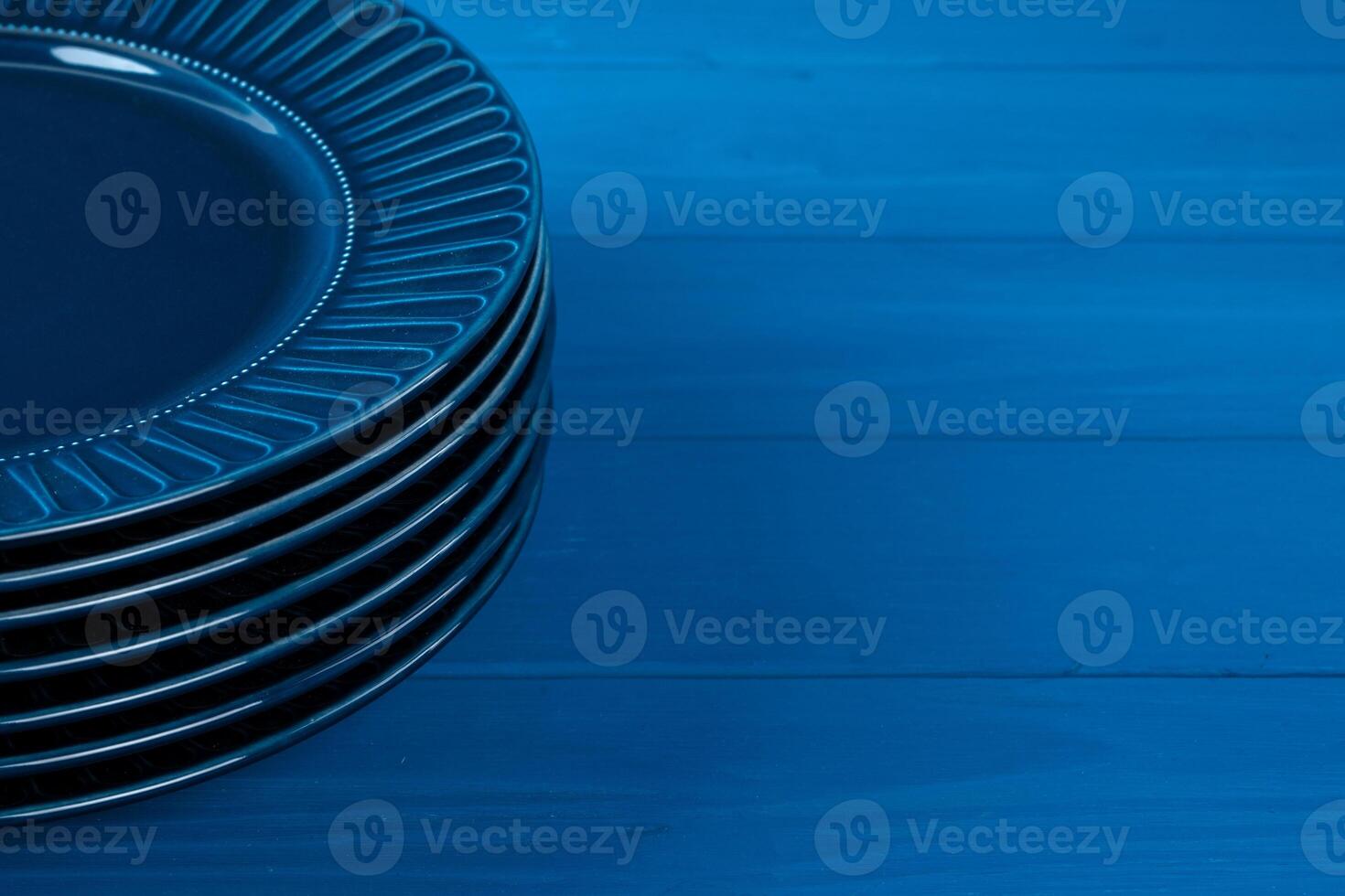 Dark blue crockery on blue wooden background photo