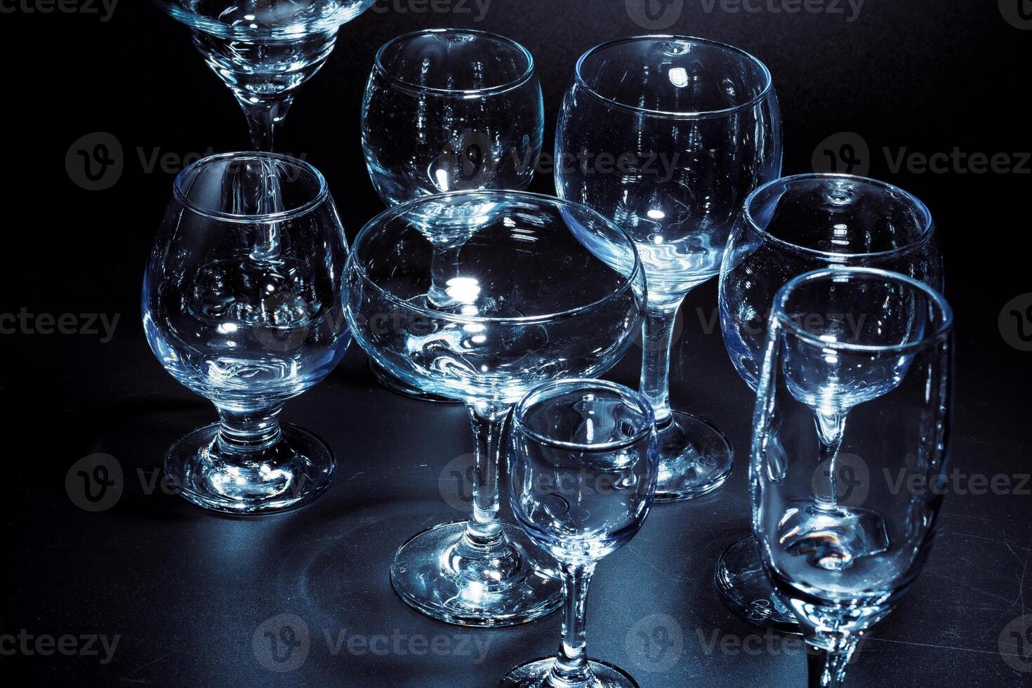Empty glasses for drinks on dark background photo
