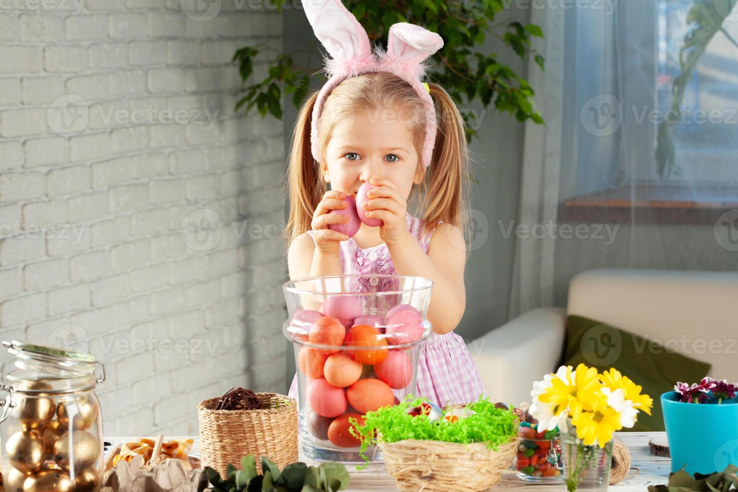 Happy little girl with bunny ears getting ready for Easter party photo