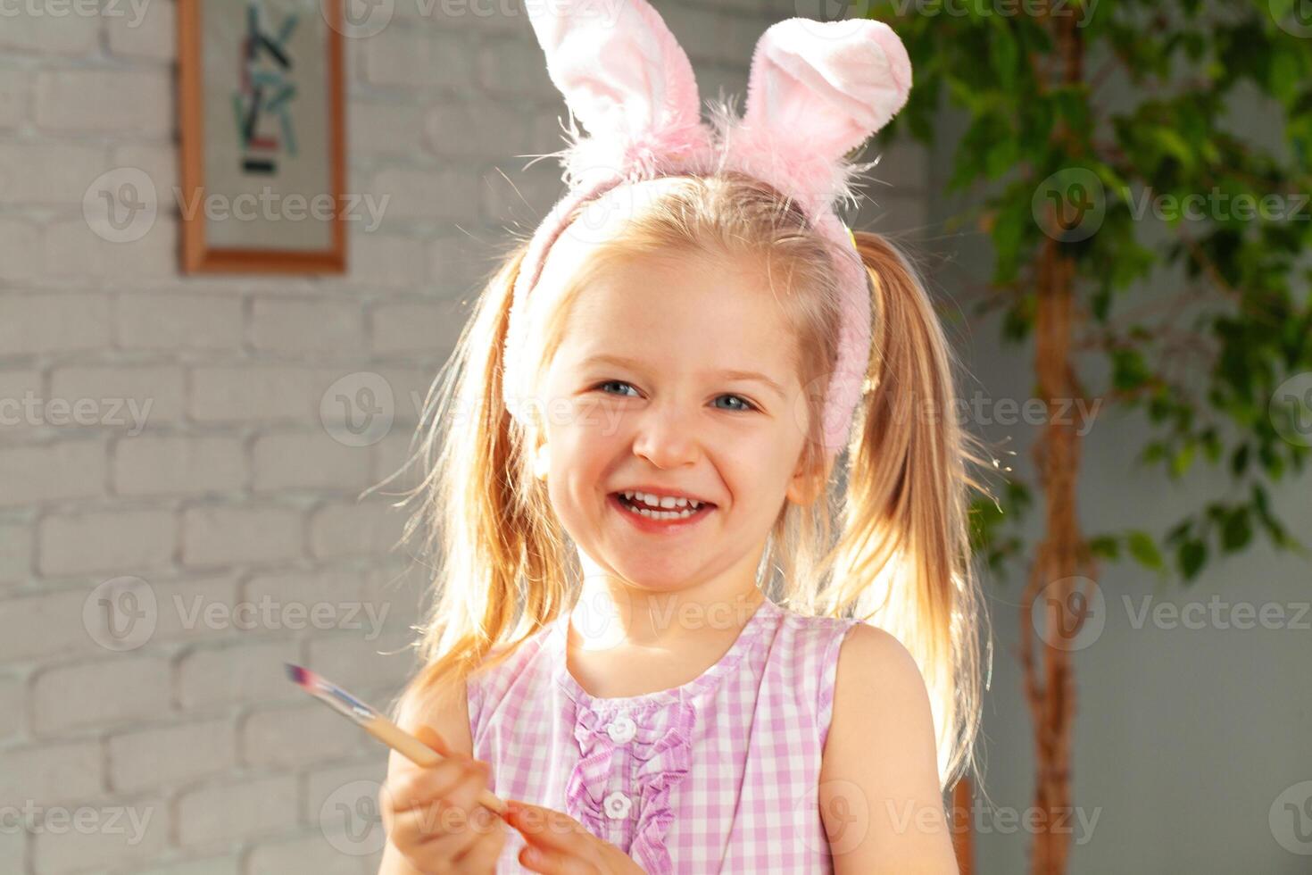 Portrait of a cute girl with paintbrush ready to paint eggs photo