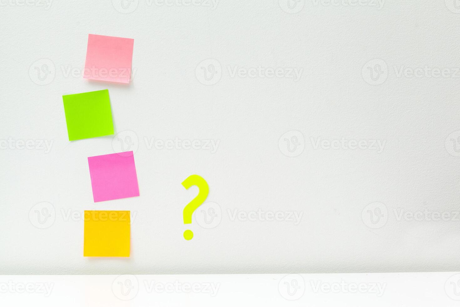 sticky notes with question marks over white photo