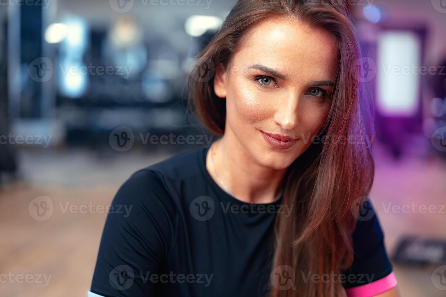 Woman fitness trainer portrait on a gym background photo