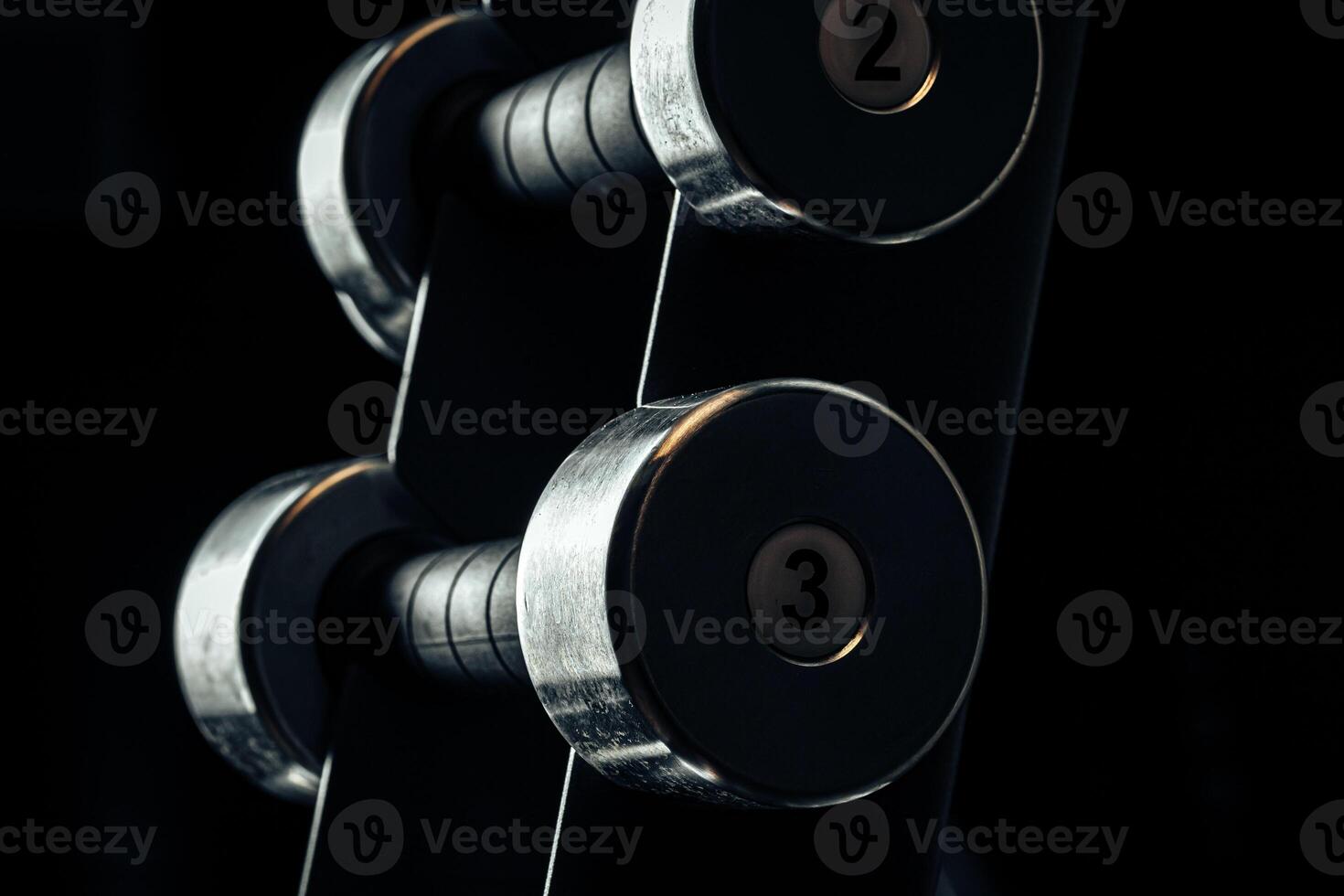 Sports equipment in gym. Dumbbells of different weight close up photo