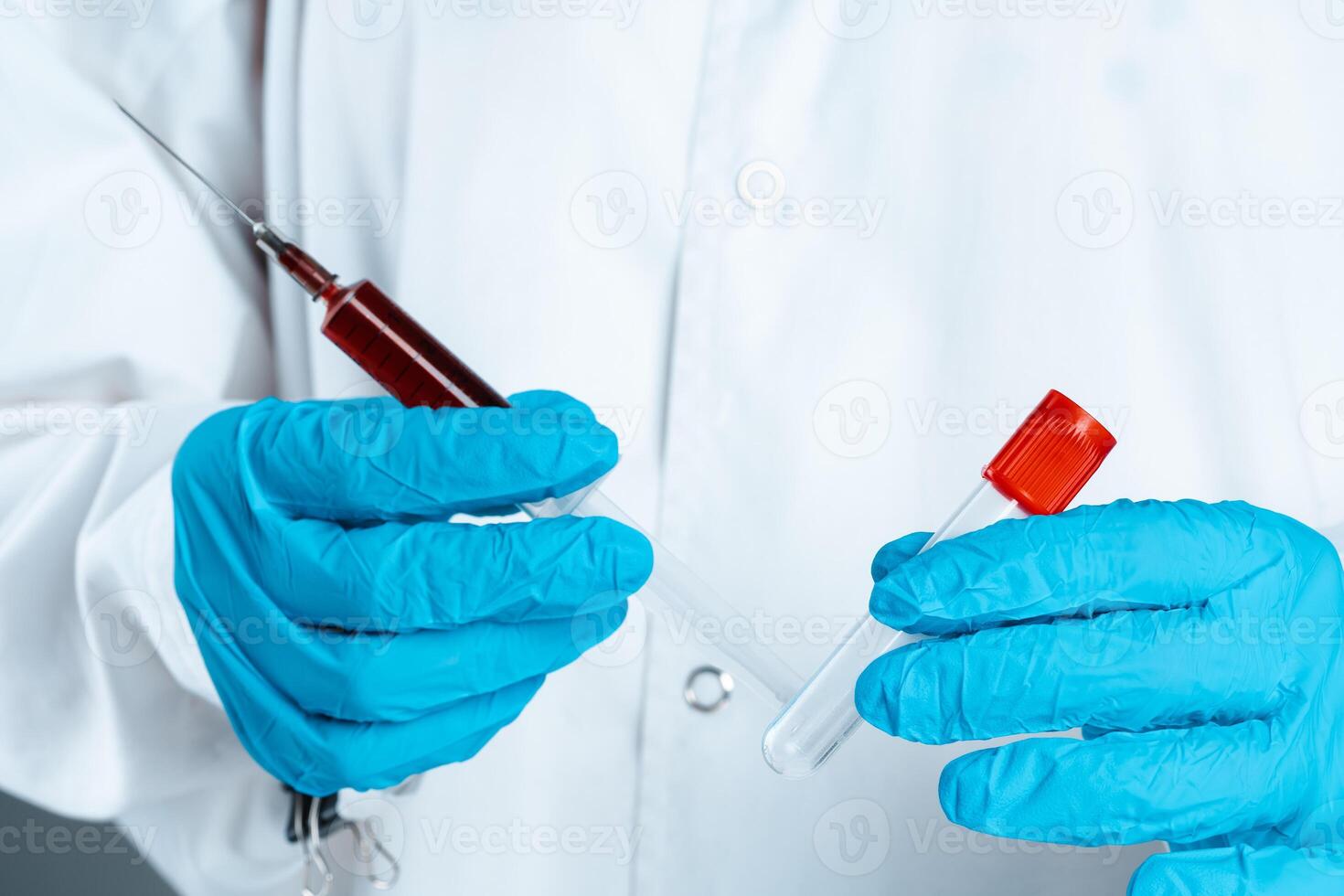 Doctor in blue gloves keep in hands test tube with a blood and syringe photo