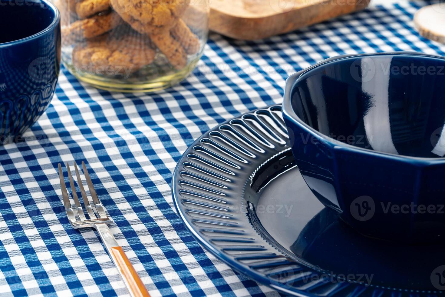 Classic blue ceramic tableware on checkered tablecloth photo