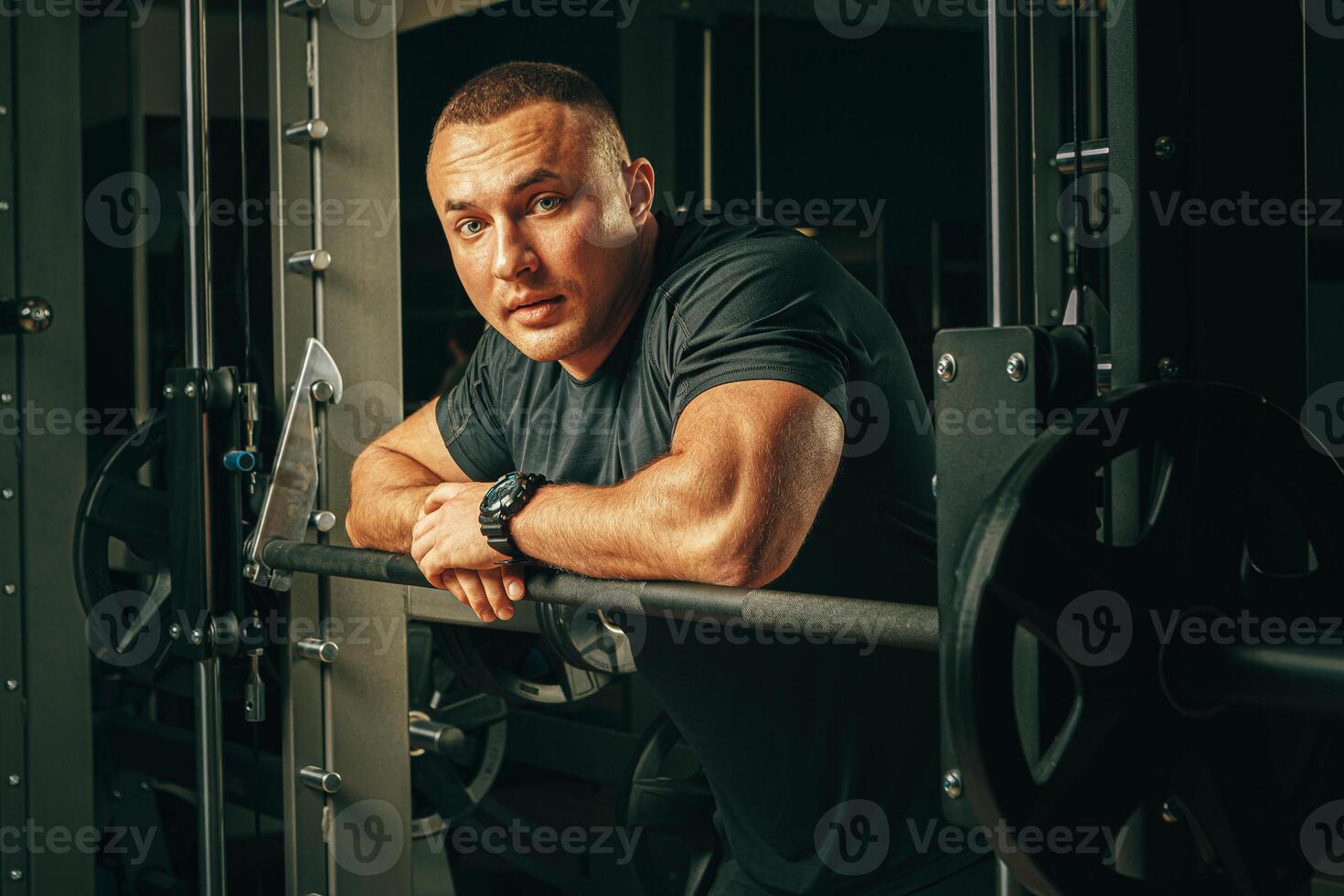 Fit man doing squats in a training machine photo