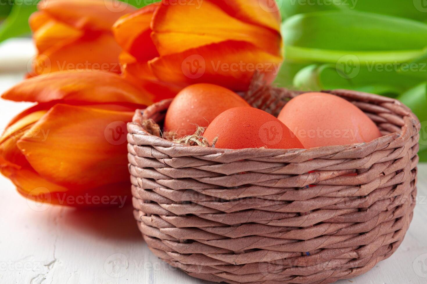 Easter composition with tulips and basket of painted eggs photo