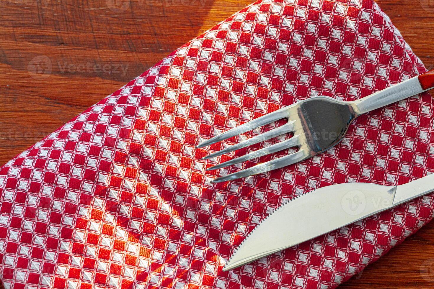 Red checkered napkin or tablecloth on wooden table photo