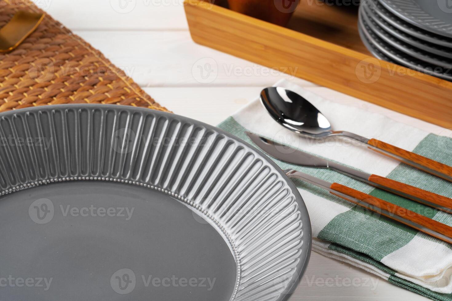 Glossy grey ceramic plate with cutlery on wooden table photo