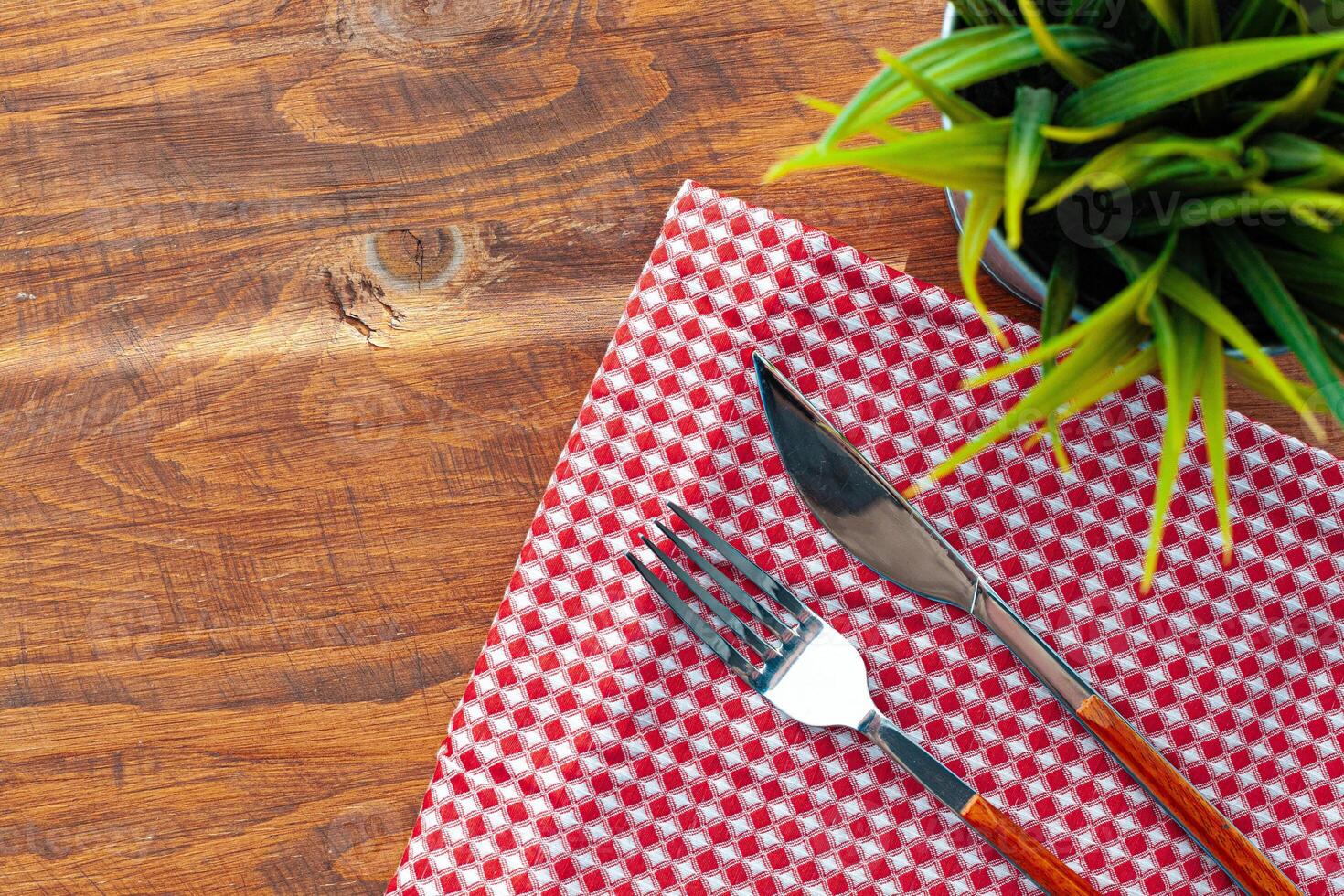 Red checkered napkin or tablecloth on wooden table photo
