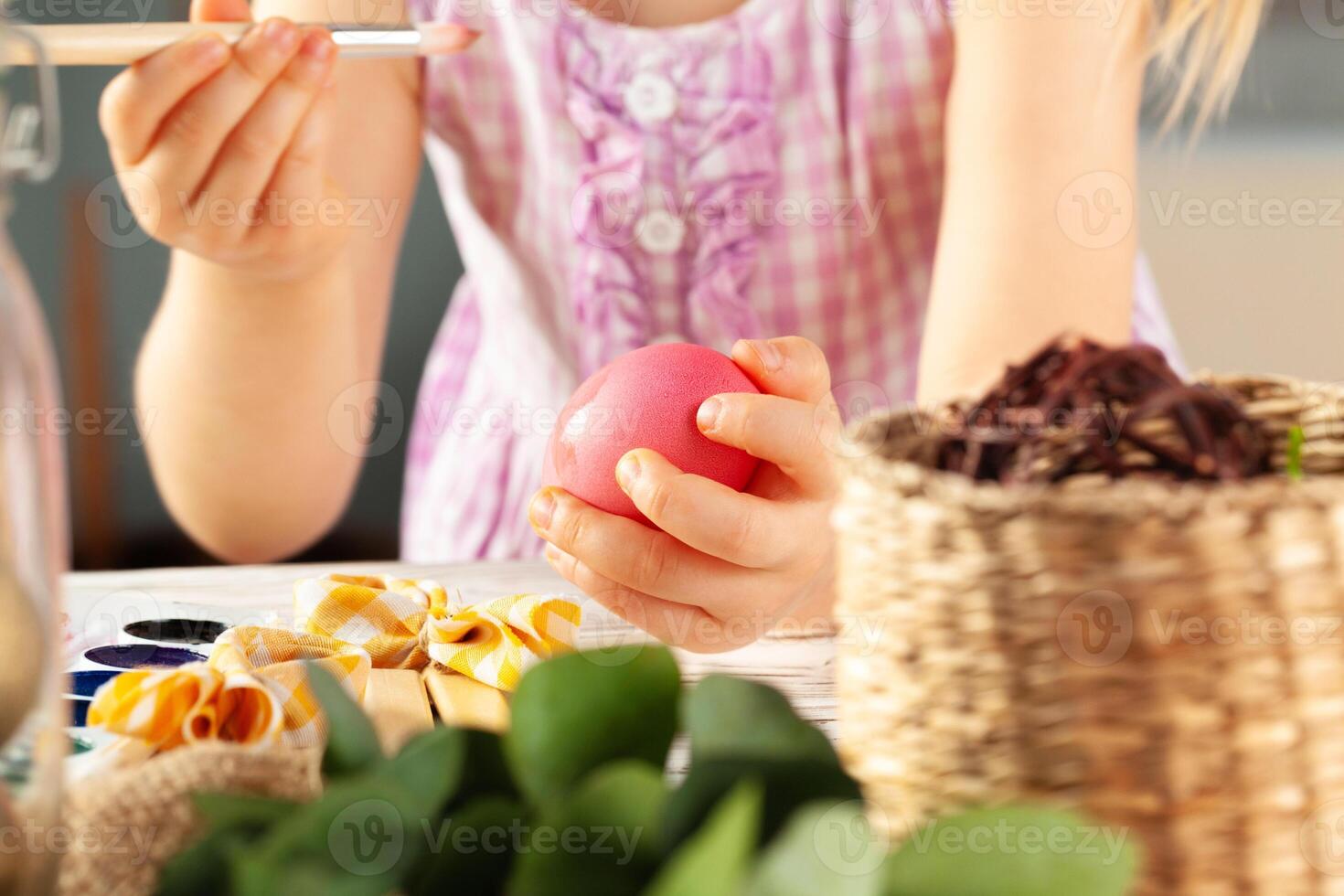 Cropped image of a little girl painting eggs for Easter photo