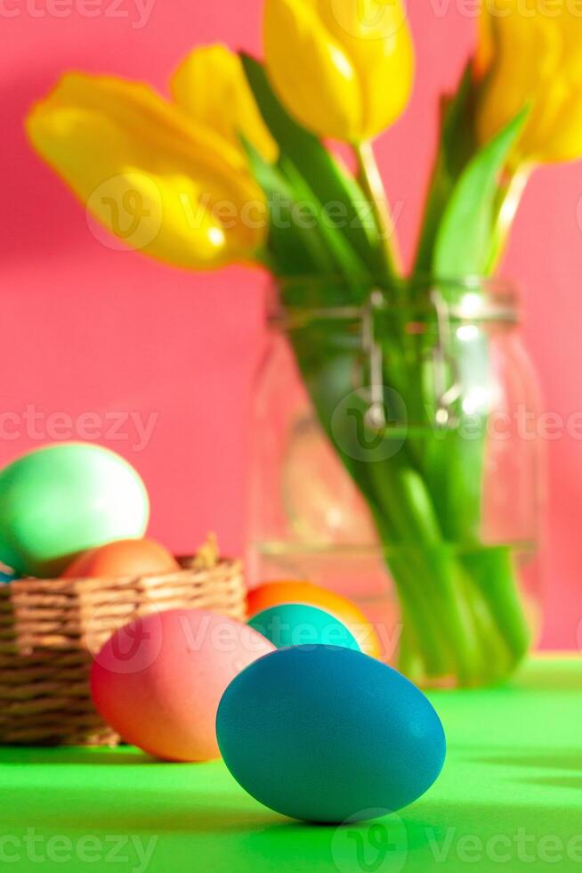 Vibrant colored eggs in a nest on green. Easter concept photo