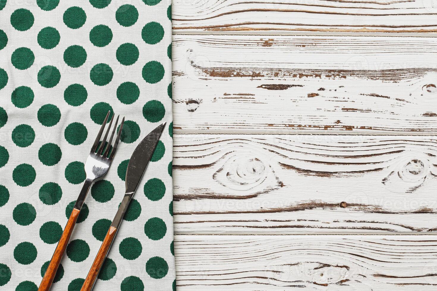 Green polka dot napkin on weathered wooden background photo