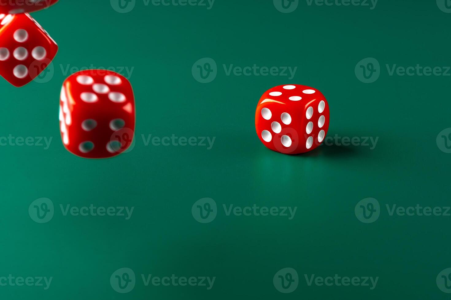 Red dice on green background close up photo