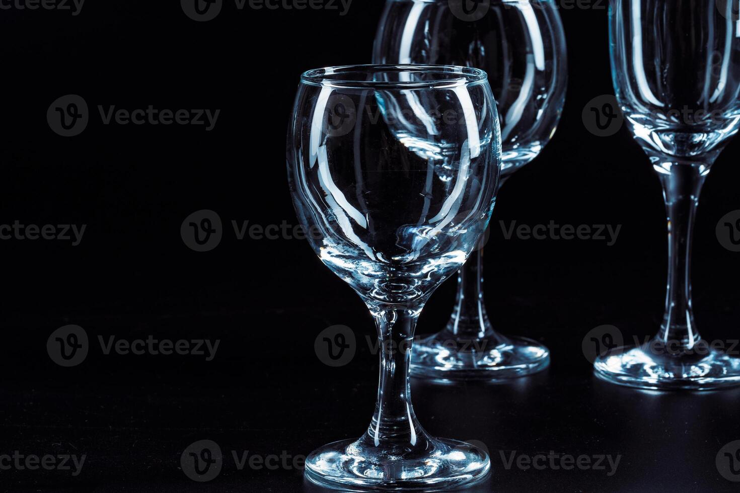 Empty glasses for drinks on dark background photo