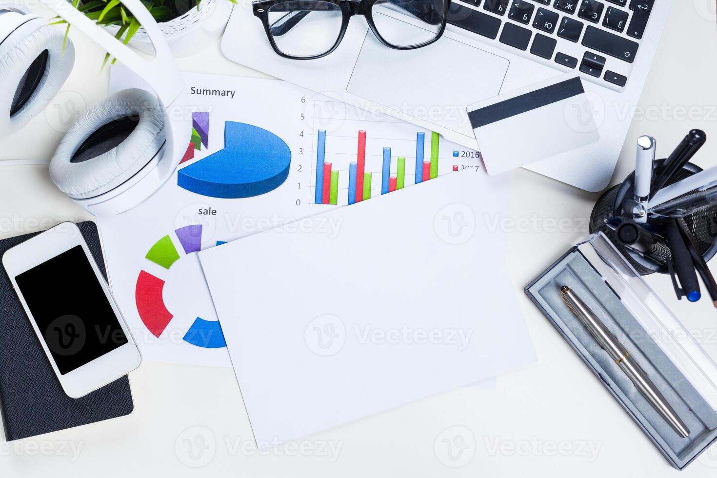 White office desk table with a lot of things on it. Top view photo