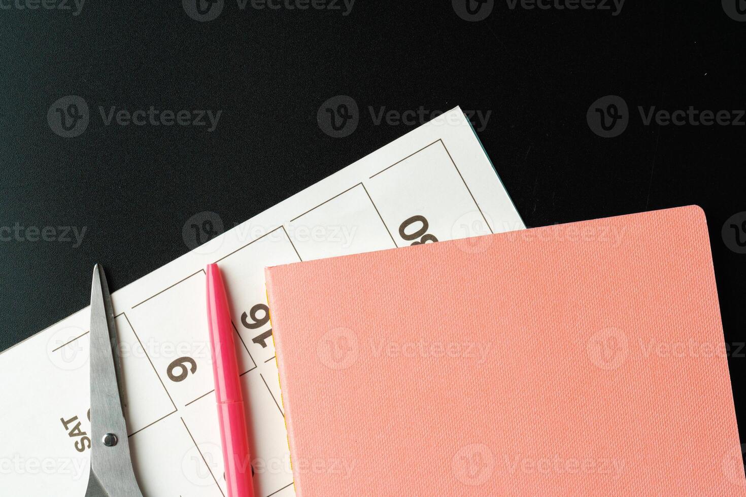 Notepad with pen and scissors on black table close up photo