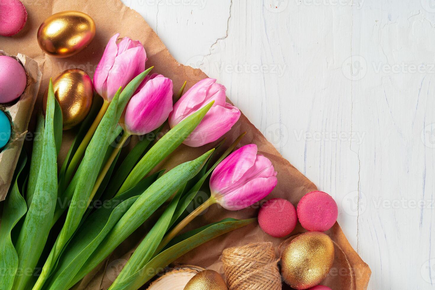 Painted Easter eggs in an eggbox with fresh tulips close up photo
