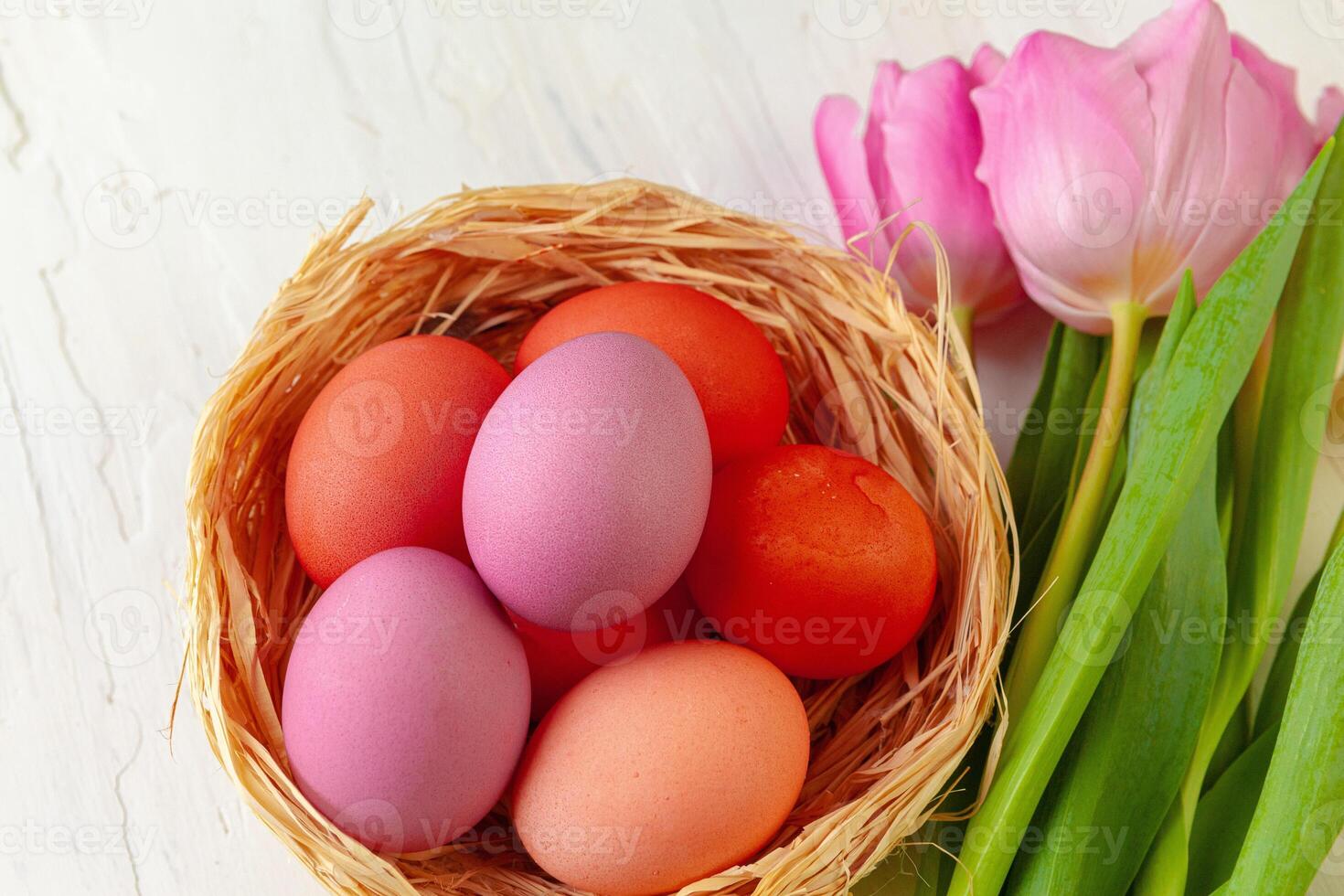 Easter composition with tulips and basket of painted eggs photo