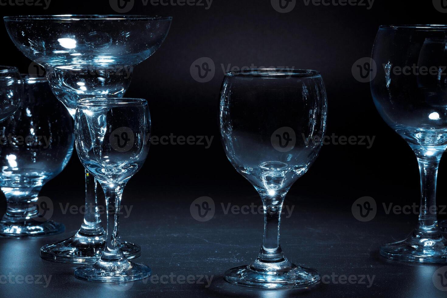 Empty glasses for drinks on dark background photo