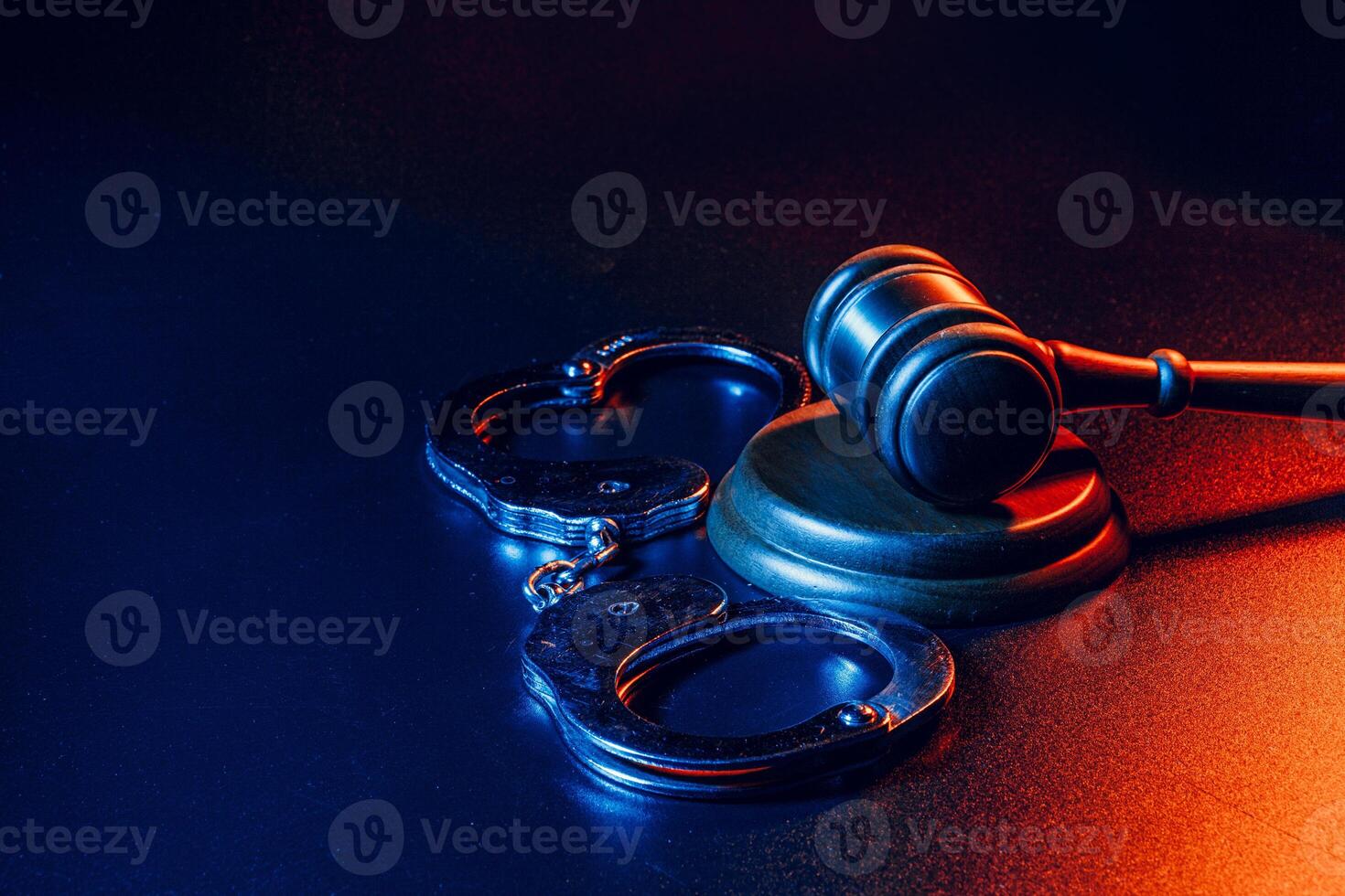 Judge gavel and handcuffs on dark black background photo