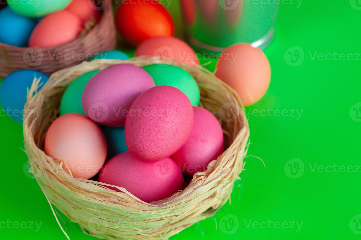 Vibrant colored eggs in a nest on green. Easter concept photo