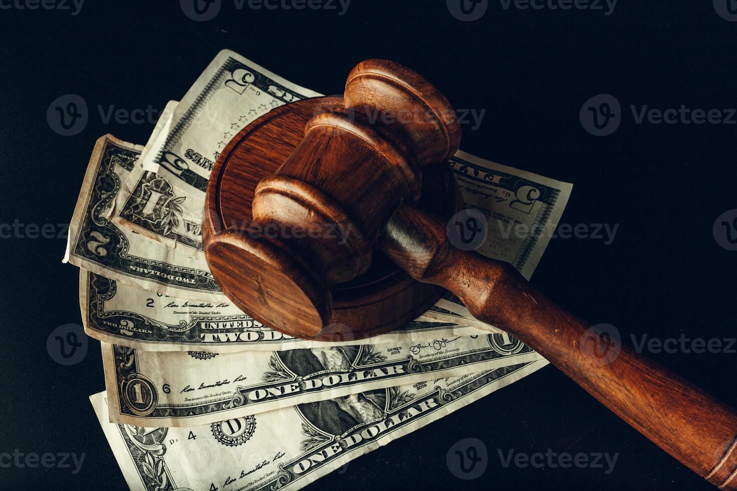 Wooden judge gavel on US dollar banknotes closeup. Justice corruption concept photo