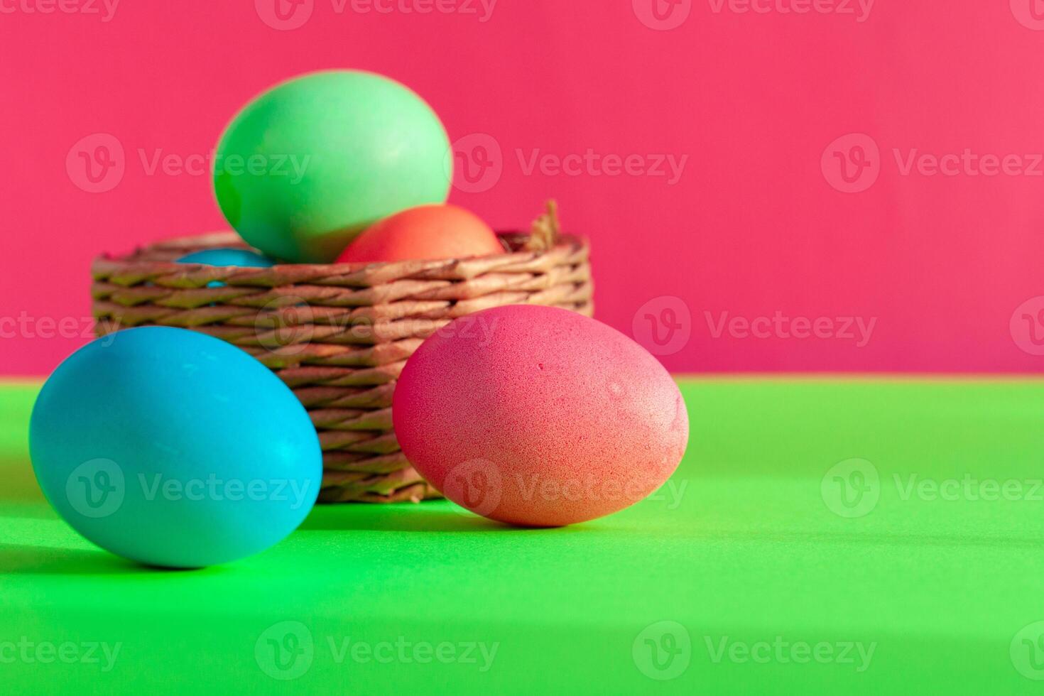 Vibrant colored eggs in a nest on green. Easter concept photo